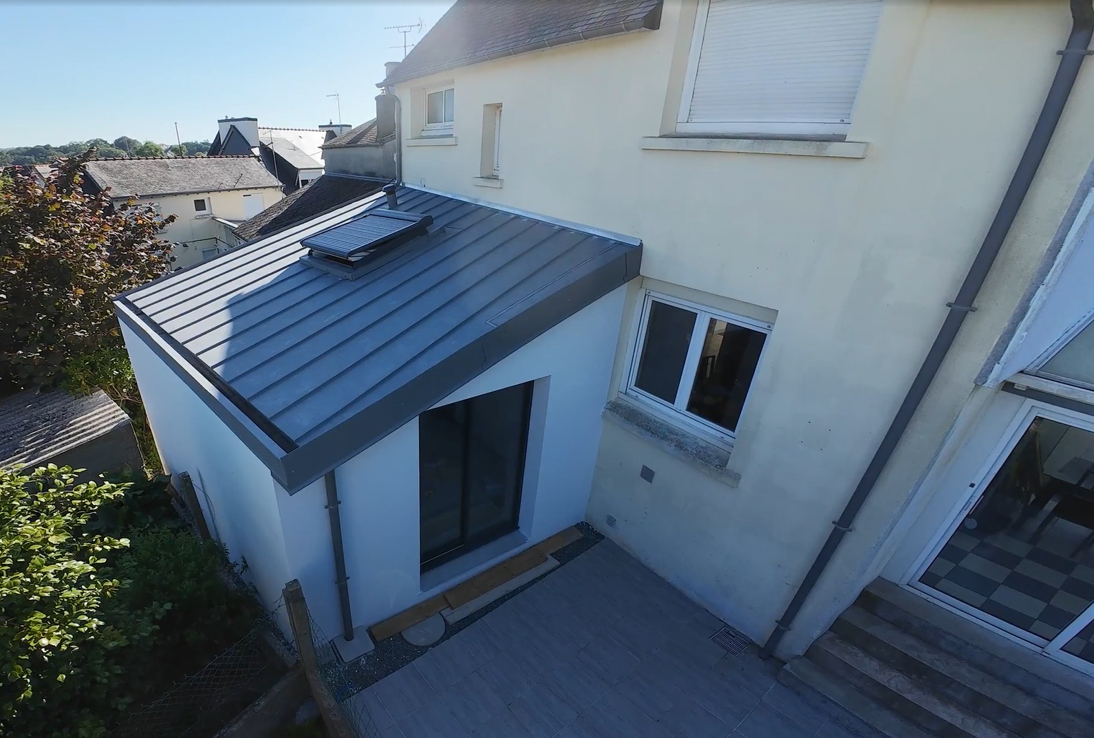 Extension de maison moderne avec toit en zinc gris.