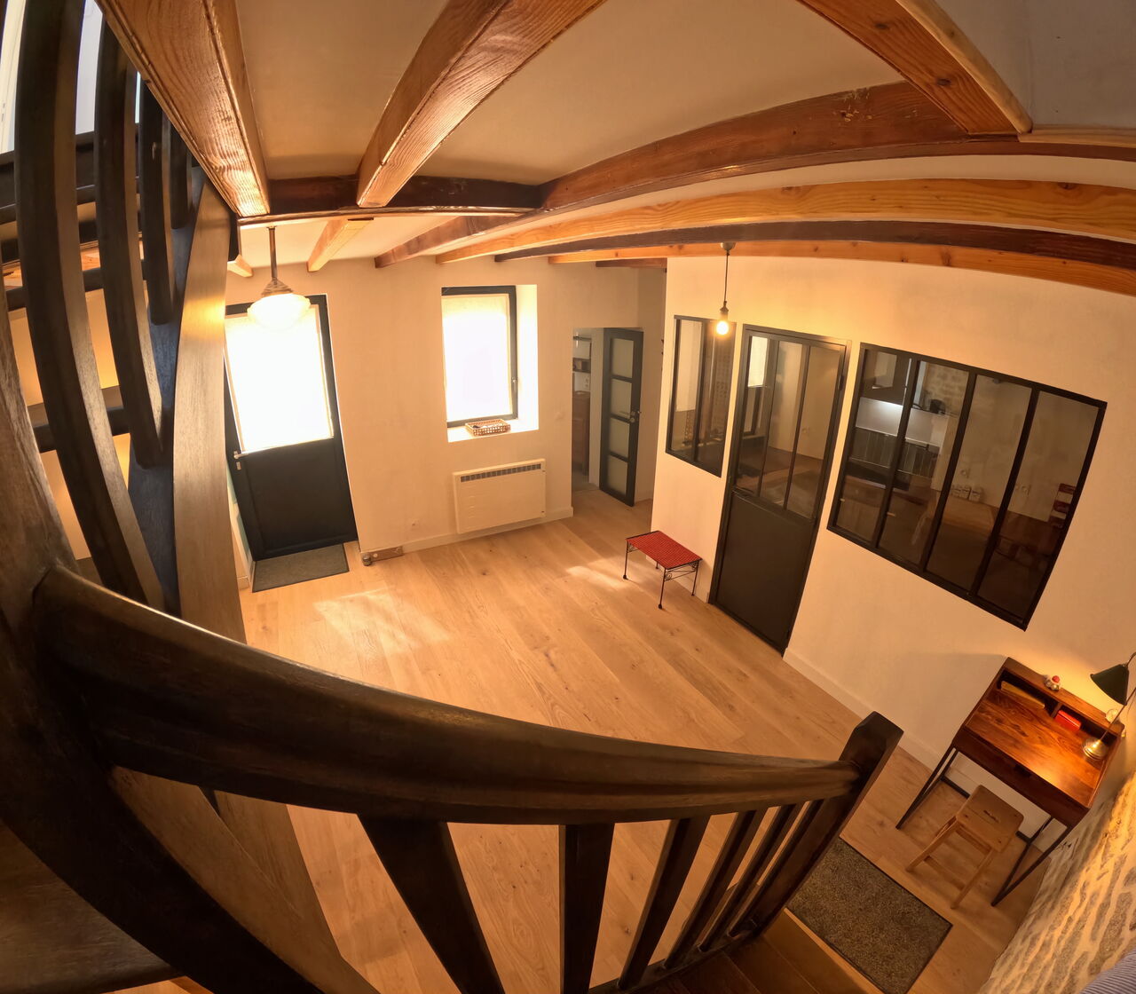 Vue plongeante d'un intérieur rustique avec poutres en bois.